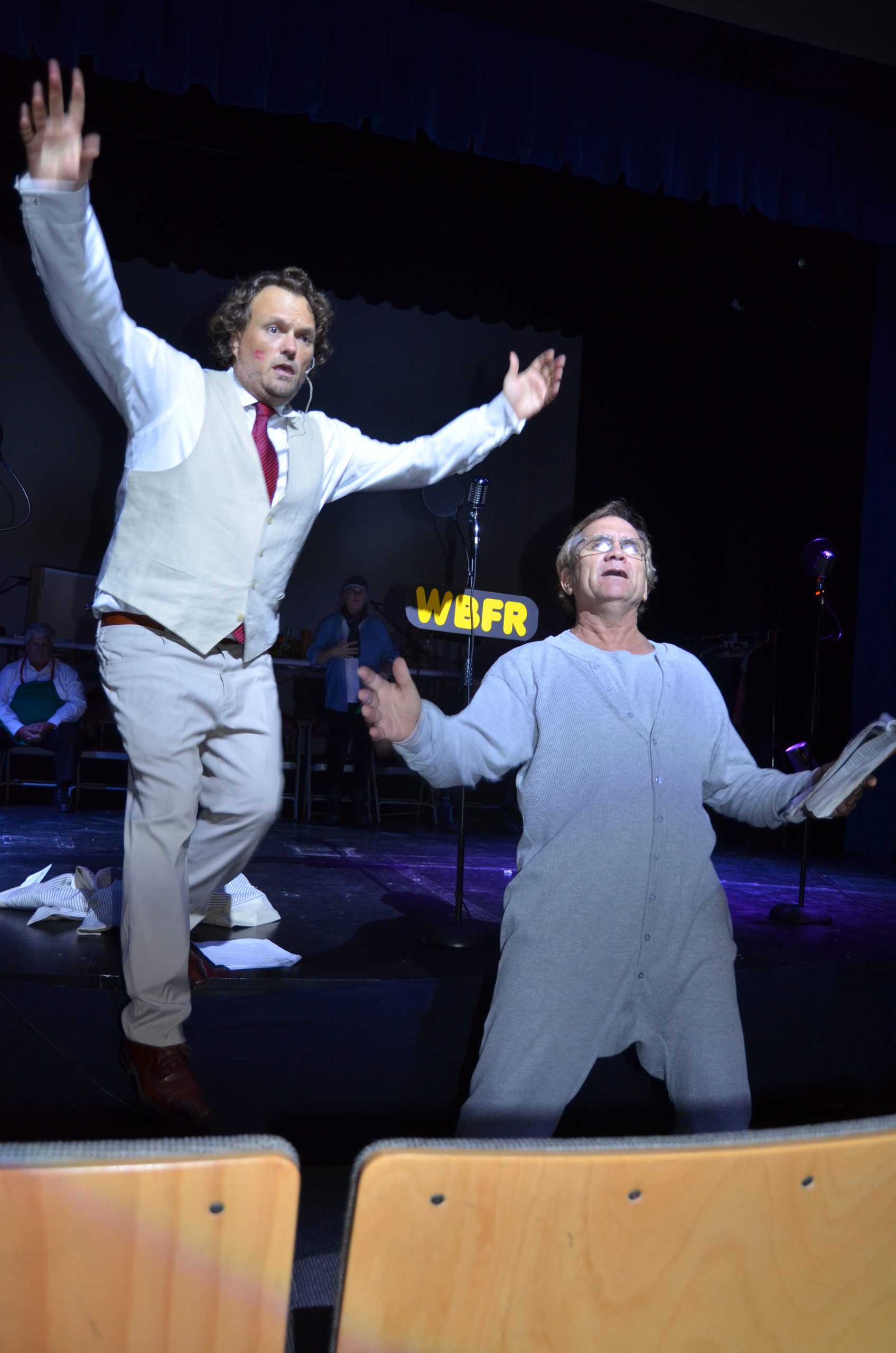 Two male actors with arms outstretched looking upwards